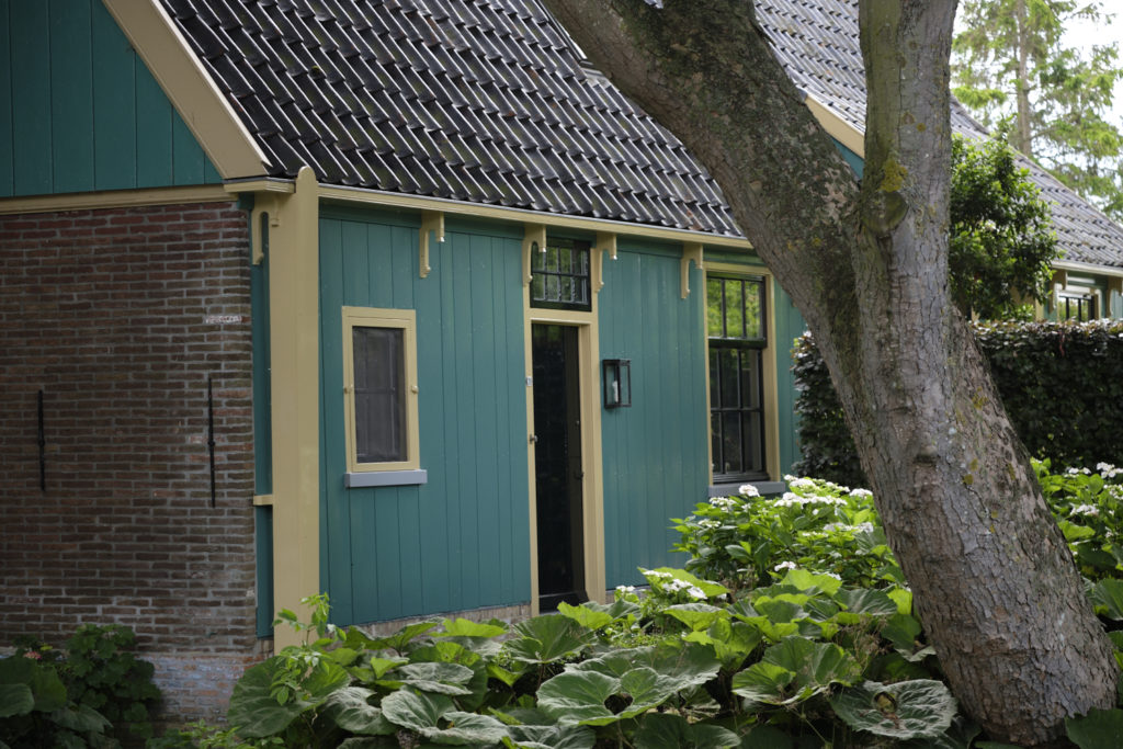 A traditional Dutch house with teal wooden paneling