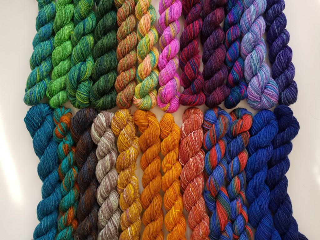 24 mini skeins, arranged in two rows, ordered by colour.