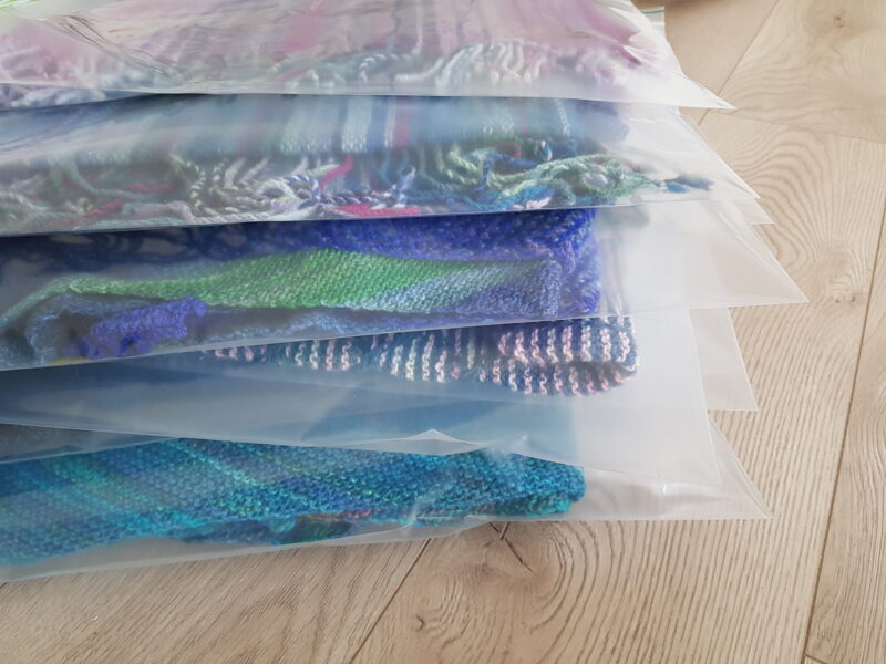 A pile of zip locs containing hand knit items.